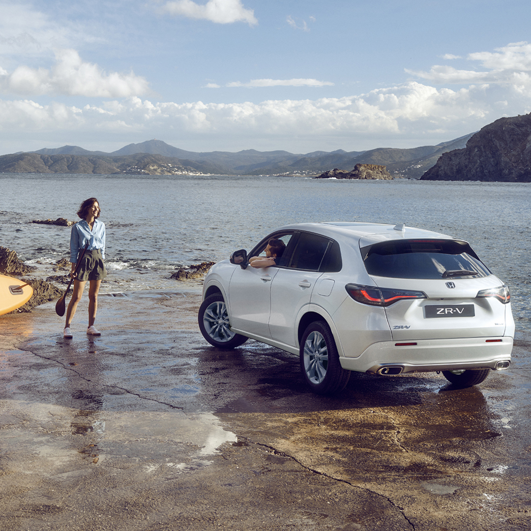 ZR-V bianco sulla costa con donna e canoa