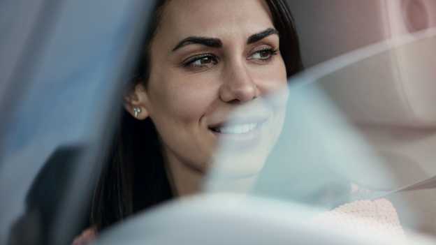Primo piano di una signora che guarda fuori dal finestrino aperto di un'auto