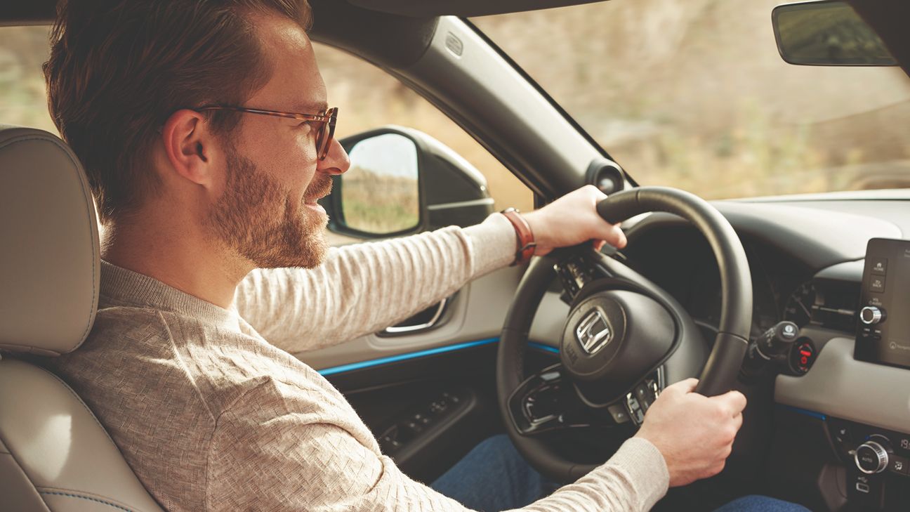 Uomo con gli occhiali alla guida di un'auto Honda