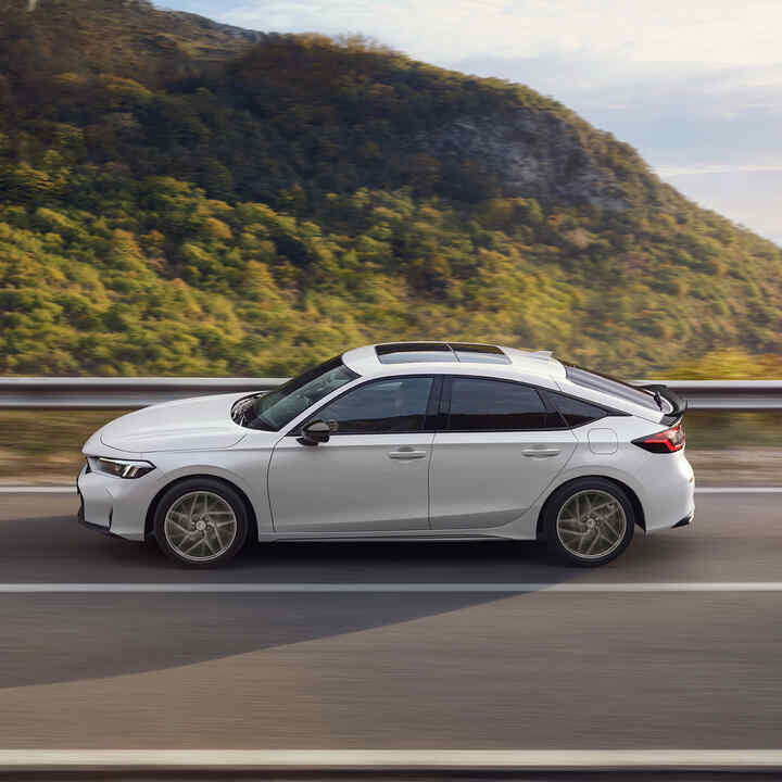 Honda Civic Hybrid in movimento su un'autostrada, con vista panoramica.