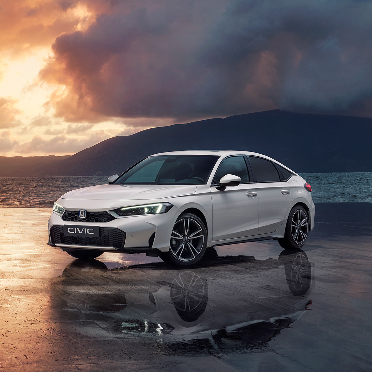 Civic Hybrid parcheggiata vicino all'oceano al tramonto.