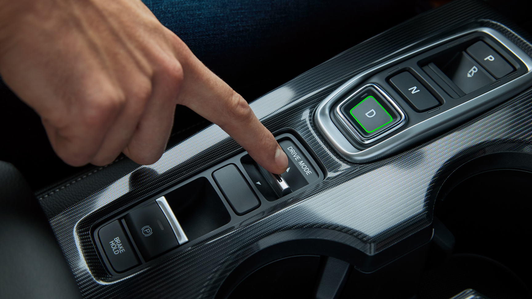 Primo piano di una persona all'interno della Civic Hybrid, mentre imposta la modalità di guida dell'auto.