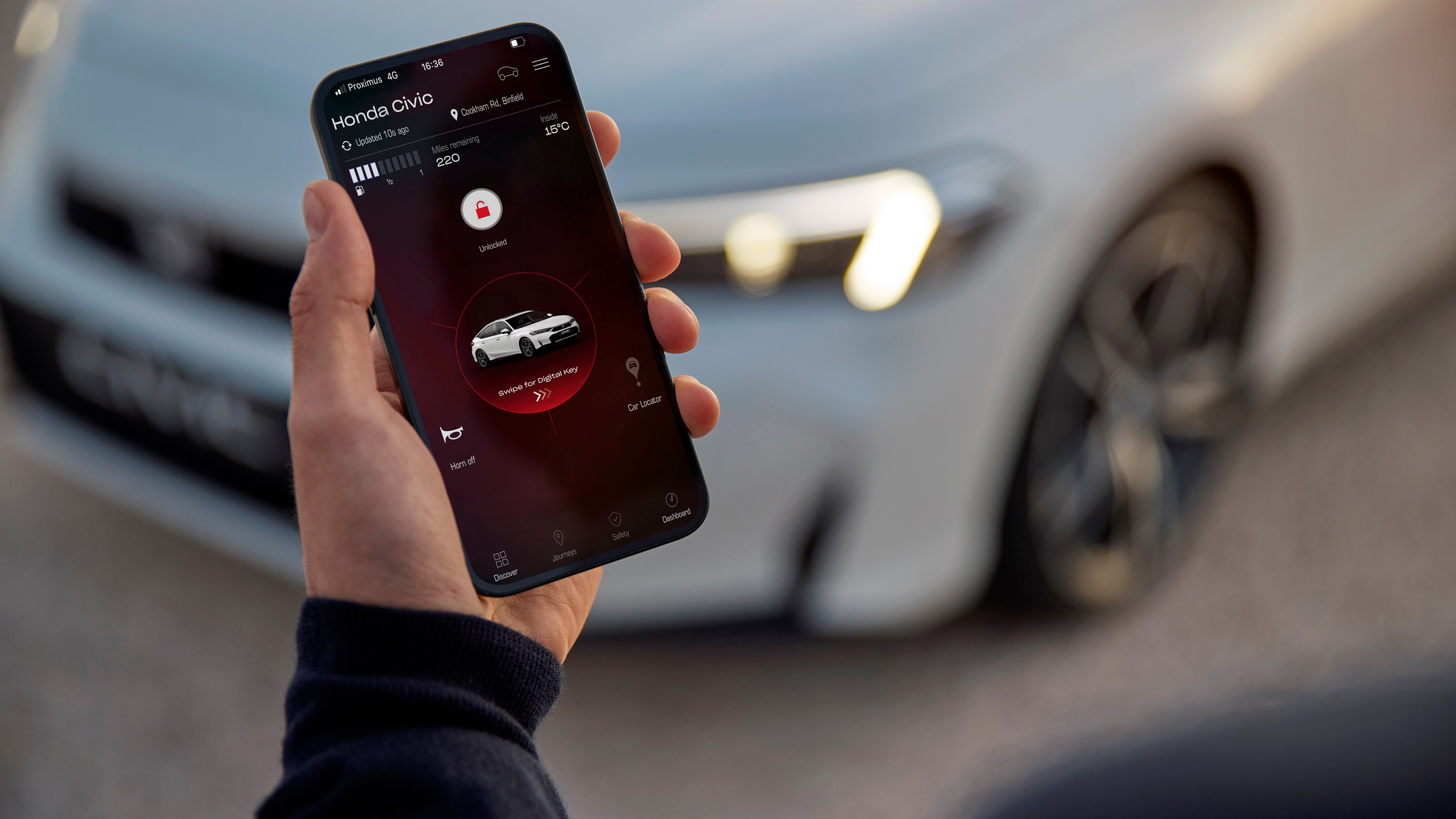 Una persona che tiene in mano uno smartphone con My Honda+ app.