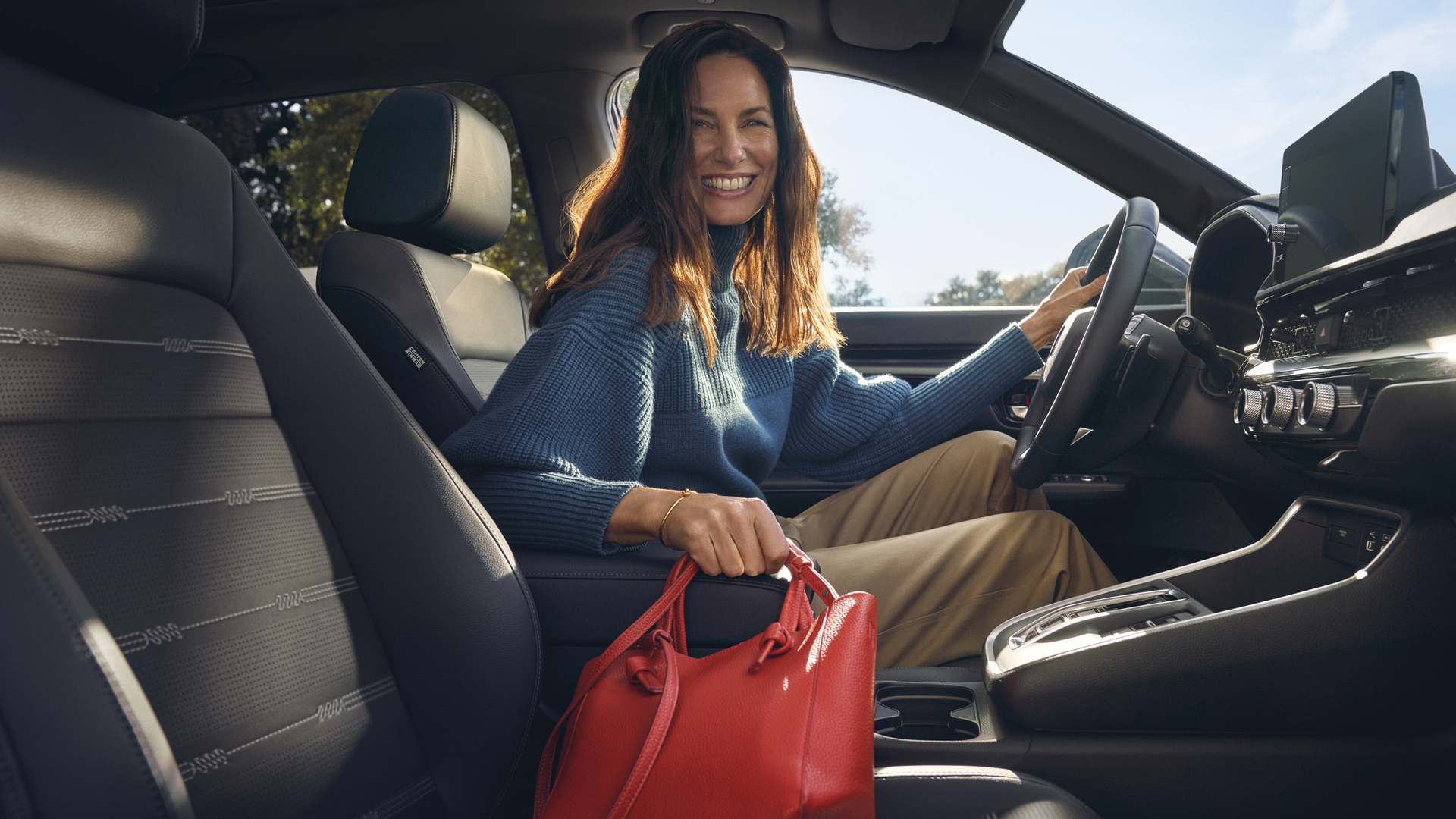 Primo piano degli interni di Honda CR-V Hybrid che mostra il vano portaoggetti nel bracciolo.