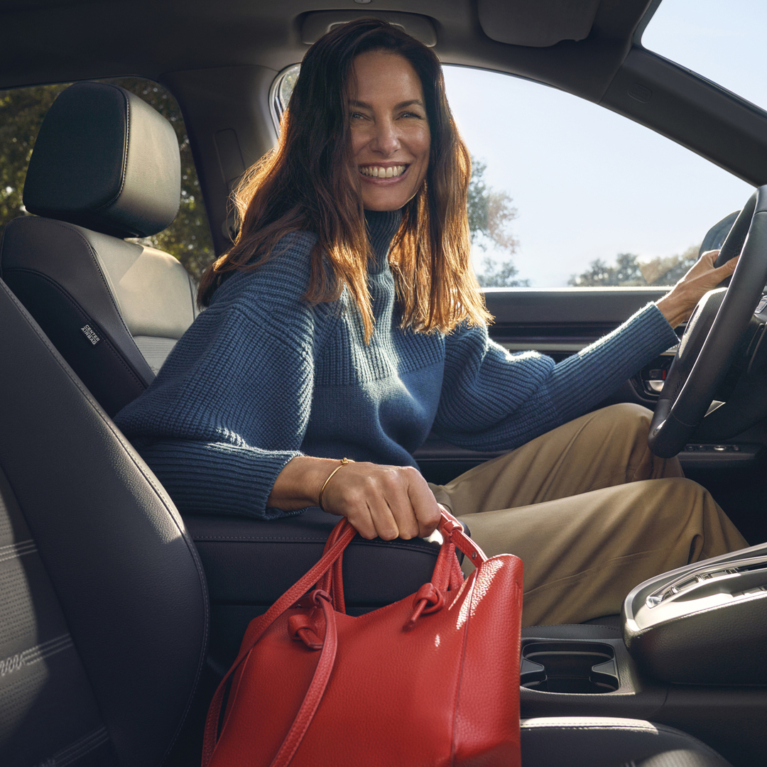 Primo piano degli interni di Honda CR-V Hybrid che mostra il vano portaoggetti nel bracciolo.