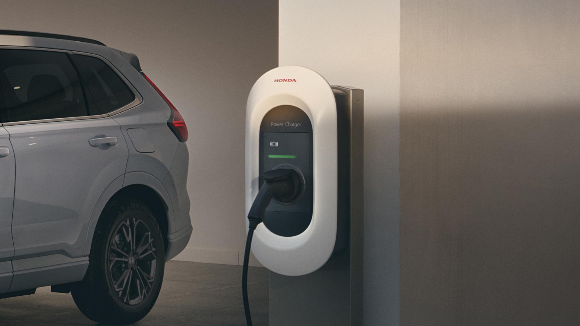 Vista frontale a tre quarti di Honda CR-V Hybrid collegato per la ricarica.