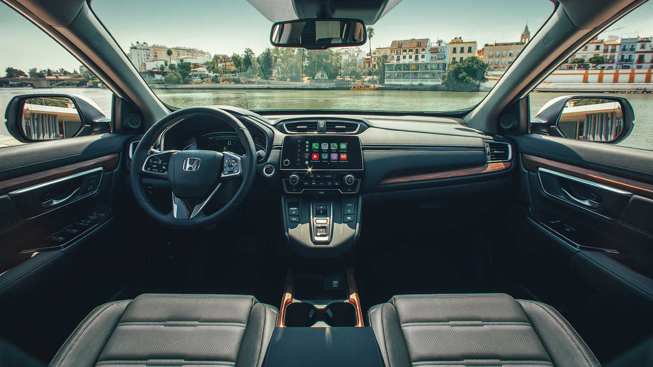 Cruscotto interno dell'Honda CR-V Hybrid che mette in mostra la caratteristica dell'ampia visuale ambientato in una strada.