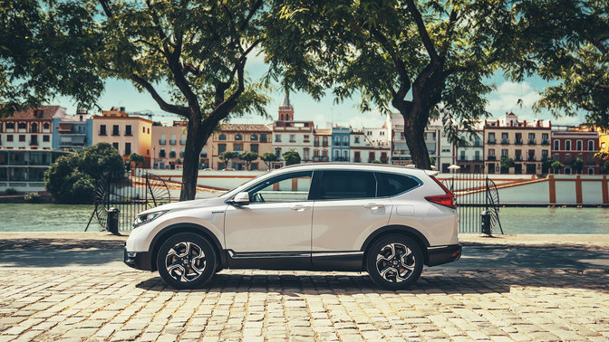 Vista laterale Honda CR-V Hybrid ambientata in una strada.