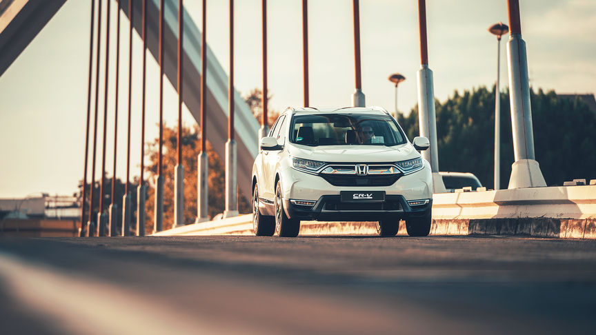 Immagine frontale di tre quarti dell'Honda CR-V Hybrid ambientata in una strada.