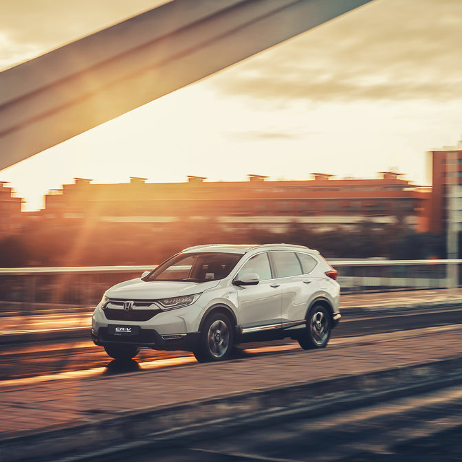 Vista laterale dell'Honda CR-V Hybrid ambientata in una strada.