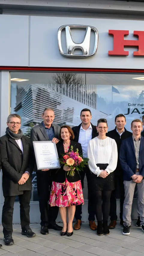 Gruppo di rivenditori che festeggiano il loro premio Yūshū per i concessionari. 