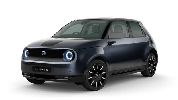 Charge yellow Honda e Side facing three quarter.