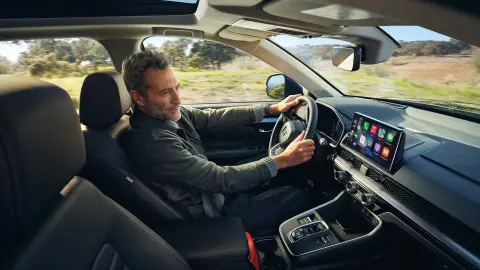 Modello seduto all'interno di CR-V Hybrid mentre utilizza Honda Sensing 360.