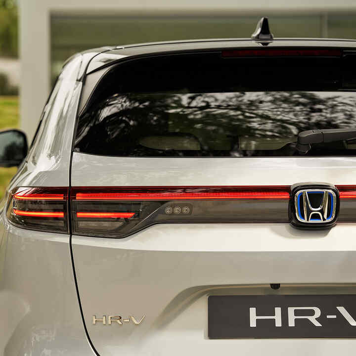 Coppia che cammina accanto all'HR-V parcheggiato fuori dall'edificio. 