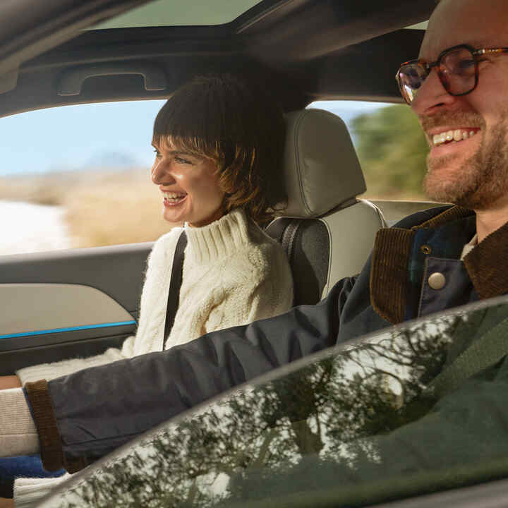 Coppia sorridente all'interno dell'auto. 