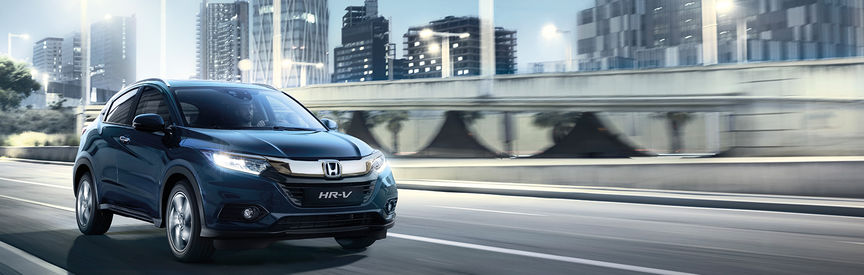 auto su strada Honda_HR-V con città sullo sfondo