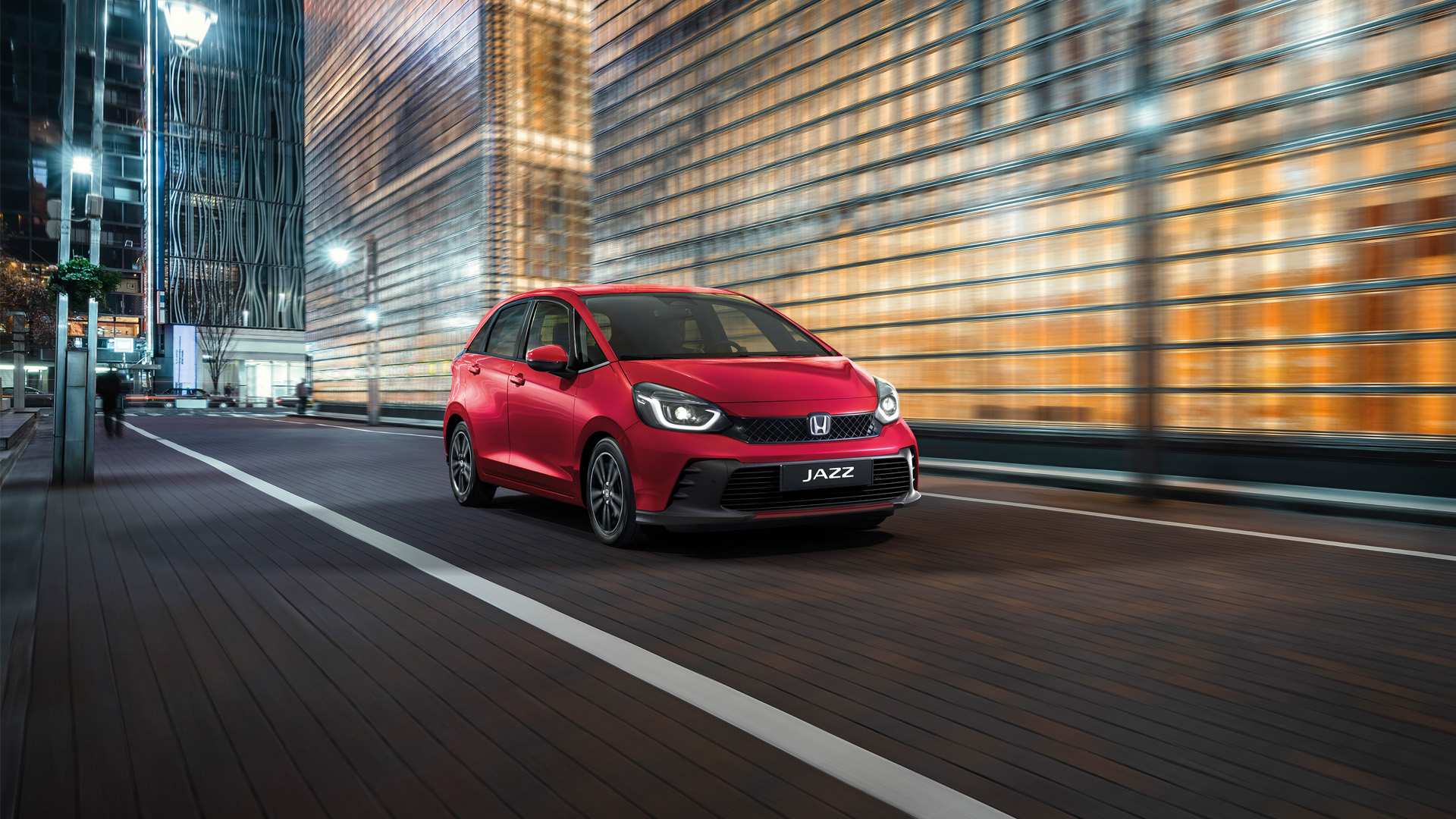 Vista anteriore di tre quarti di Honda Jazz con una città sullo sfondo.