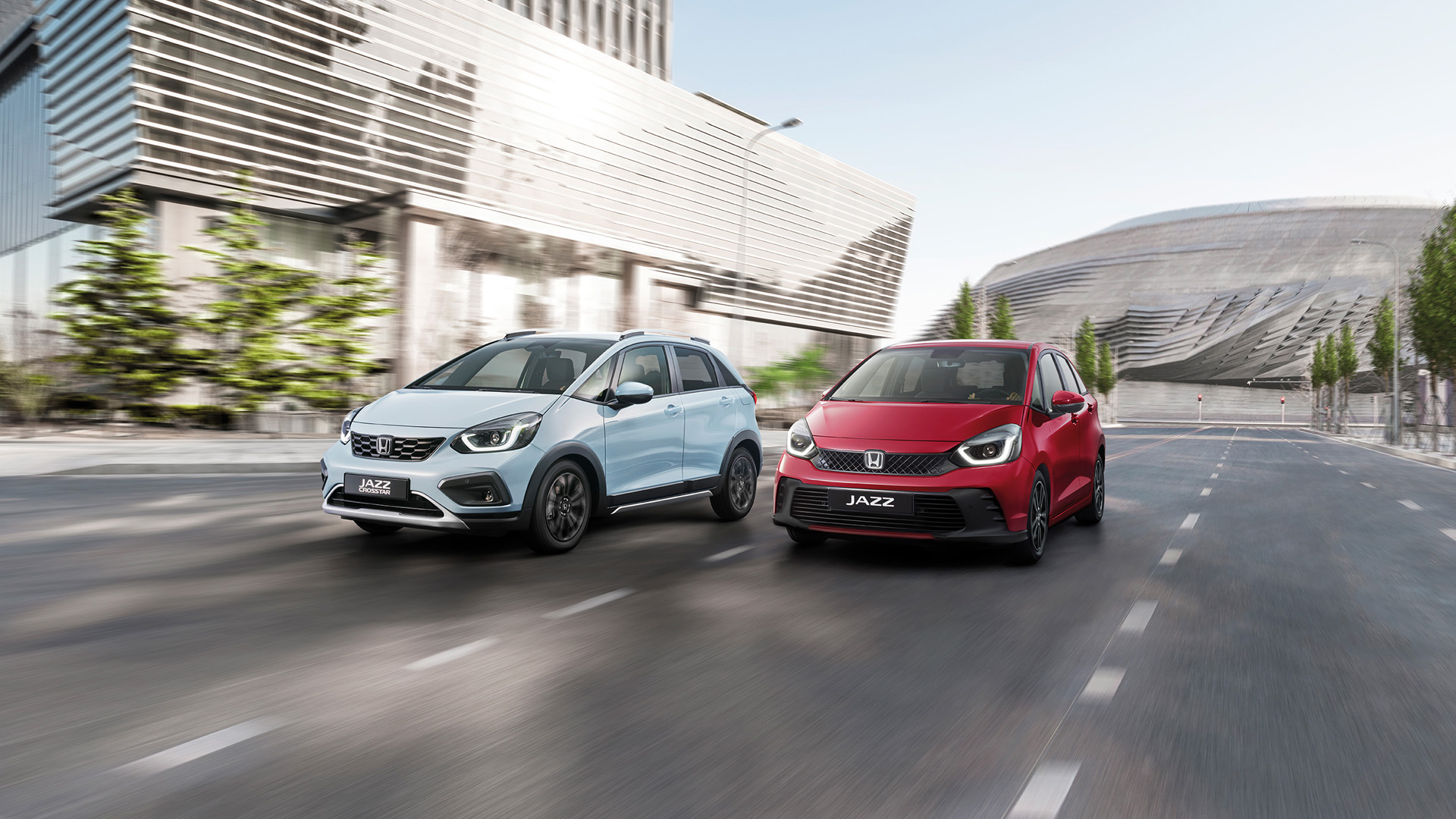 Una Honda Jazz Hybrid e una Honda Jazz Crosstar viaggiano una accanto all'altra in città.