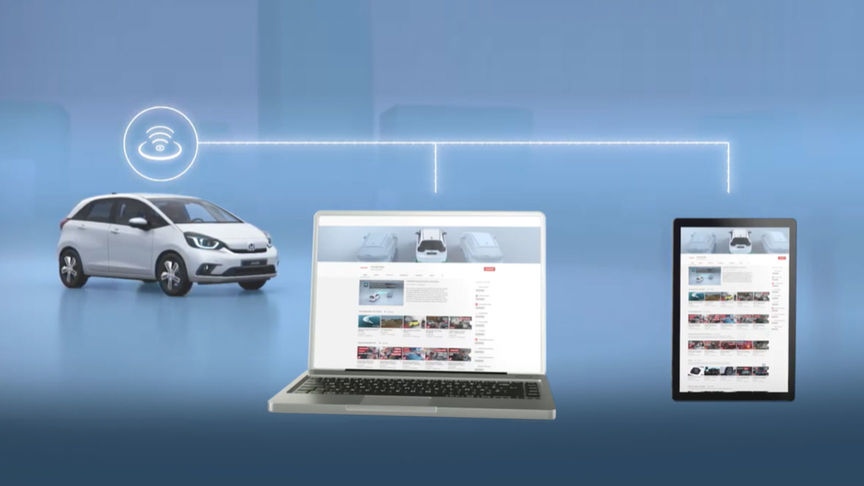 Vista frontale di tre quarti di Honda Jazz Hybrid accanto a un laptop e tablet che mostrano la connessione Wi-Fi