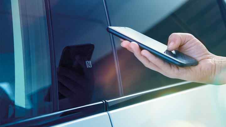 Primo piano dell'app My Honda+ di una persona che utilizza il telefono fuori dall'auto