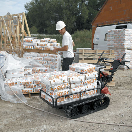 Carrello cingolato utilizzato da un operatore, in cantiere.