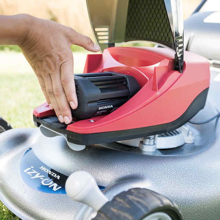 Un uomo che assembla un tagliasiepi a batteria