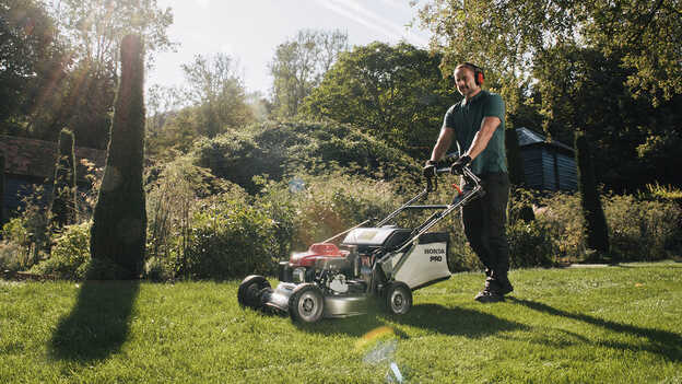 Uomo che spinge Honda HRH in giardino