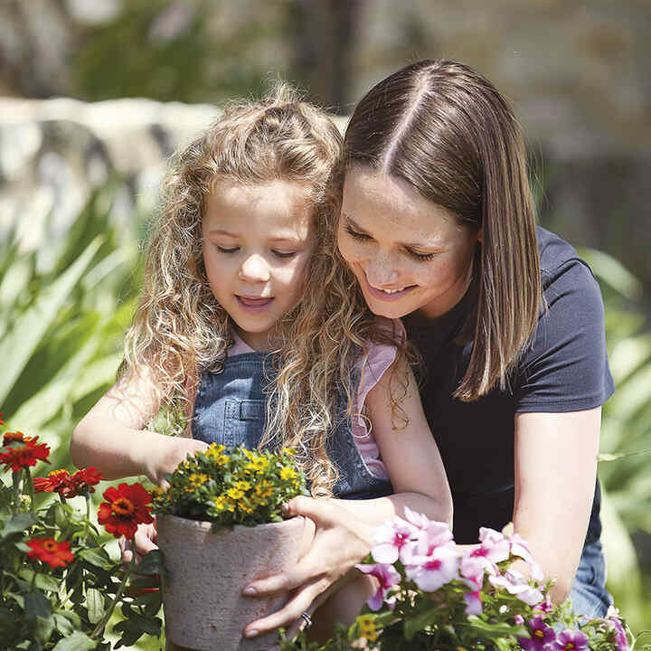 Madre e figlia che piantano fiori.