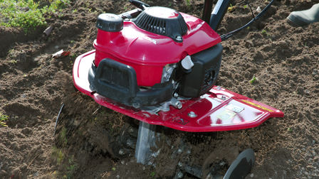 Primo piano di una mini-motozappa in uso, luogo di utilizzo: giardino.