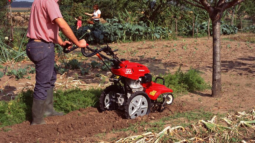 Vista anteriore della motozappa controrotante che lavora il terreno.