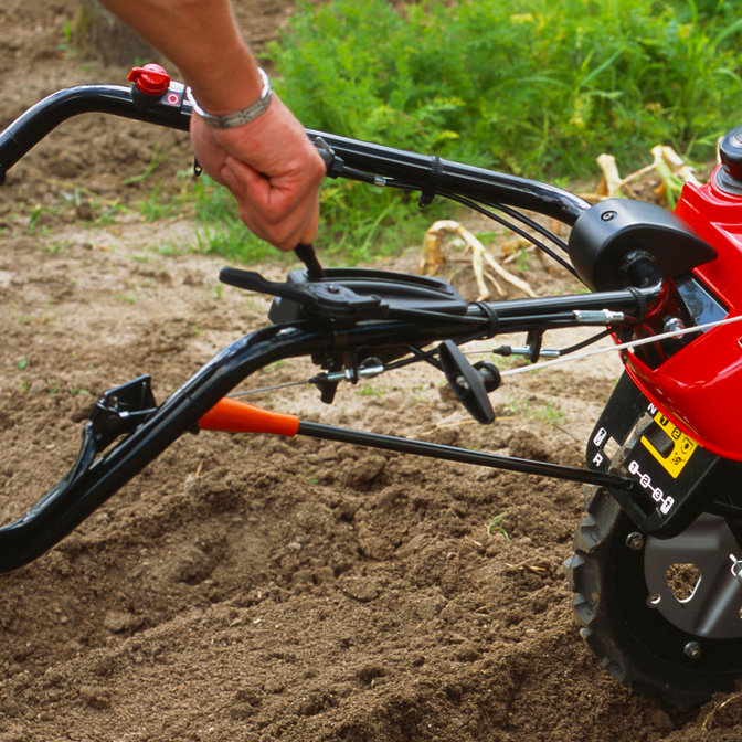 Primo piano della leva del cambio della motozappa controrotante, luogo di utilizzo: giardino.