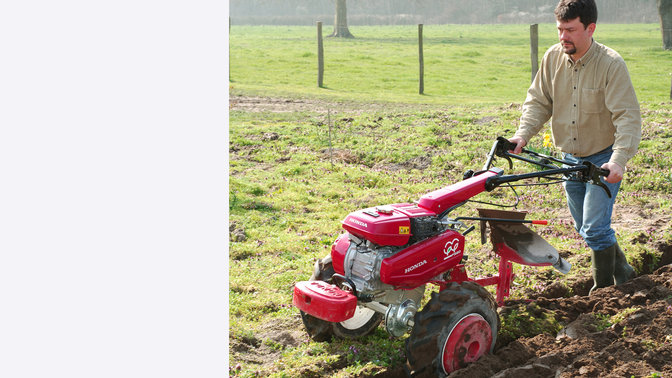 Motozappa versatile con aratro, utilizzata da un operatore, luogo di utilizzo: giardino.