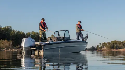 Due uomini che pescano su una barca in un lago. 