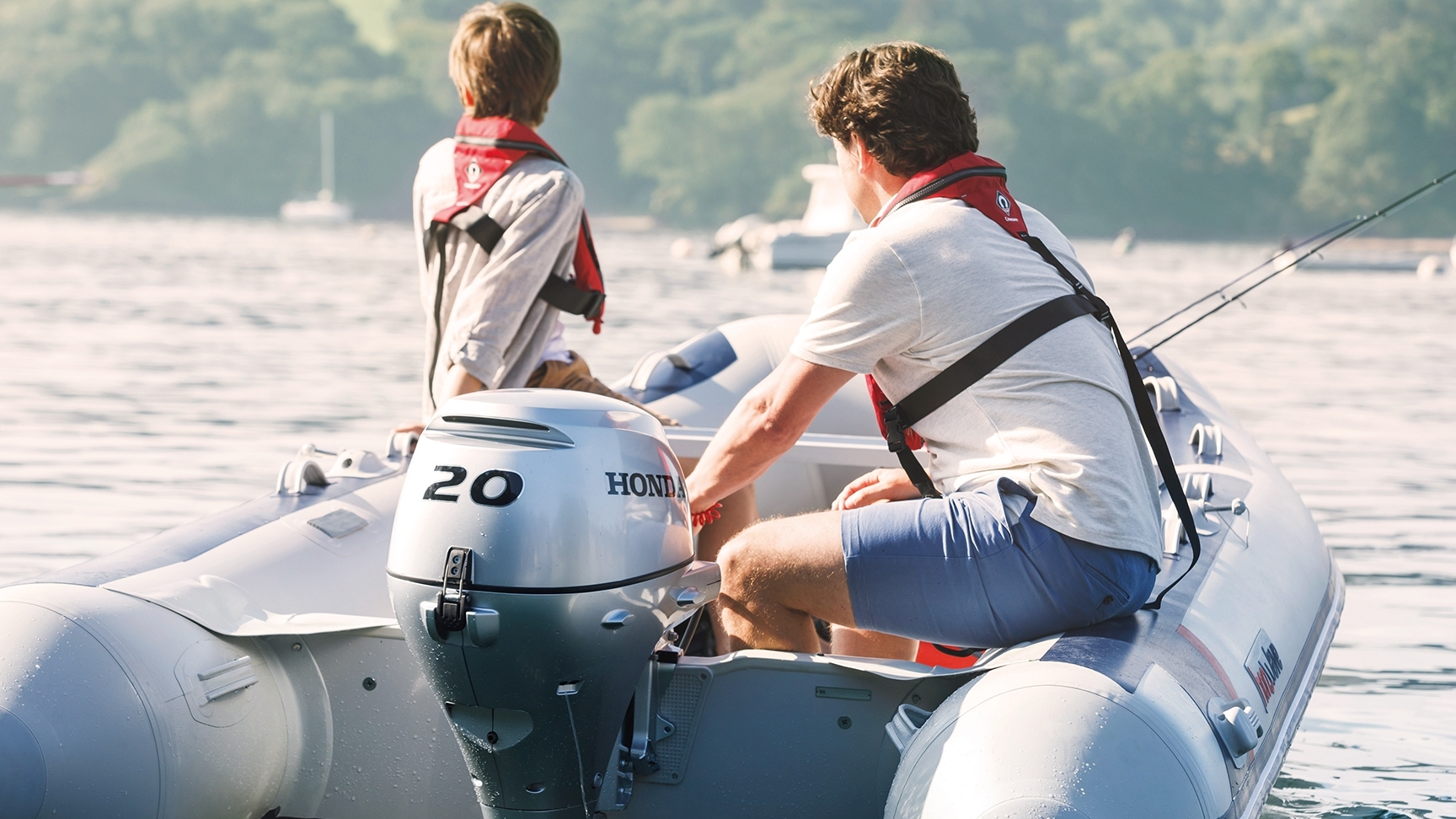 Due uomini su una barca Honwave con motore BF20 in un lago.