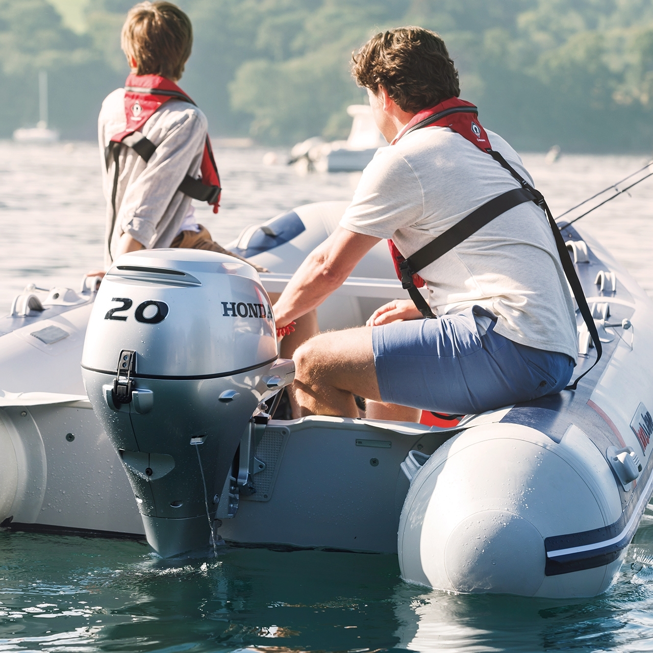 Due uomini su una barca Honwave con motore BF20 in un lago.