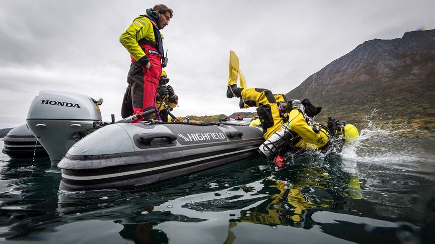 Uomo su una barca con motore BF15 in zona costiera. 