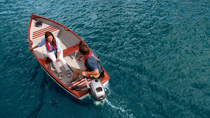 Un uomo e una donna in barca e utilizzano il motore BF2.3 per navigare