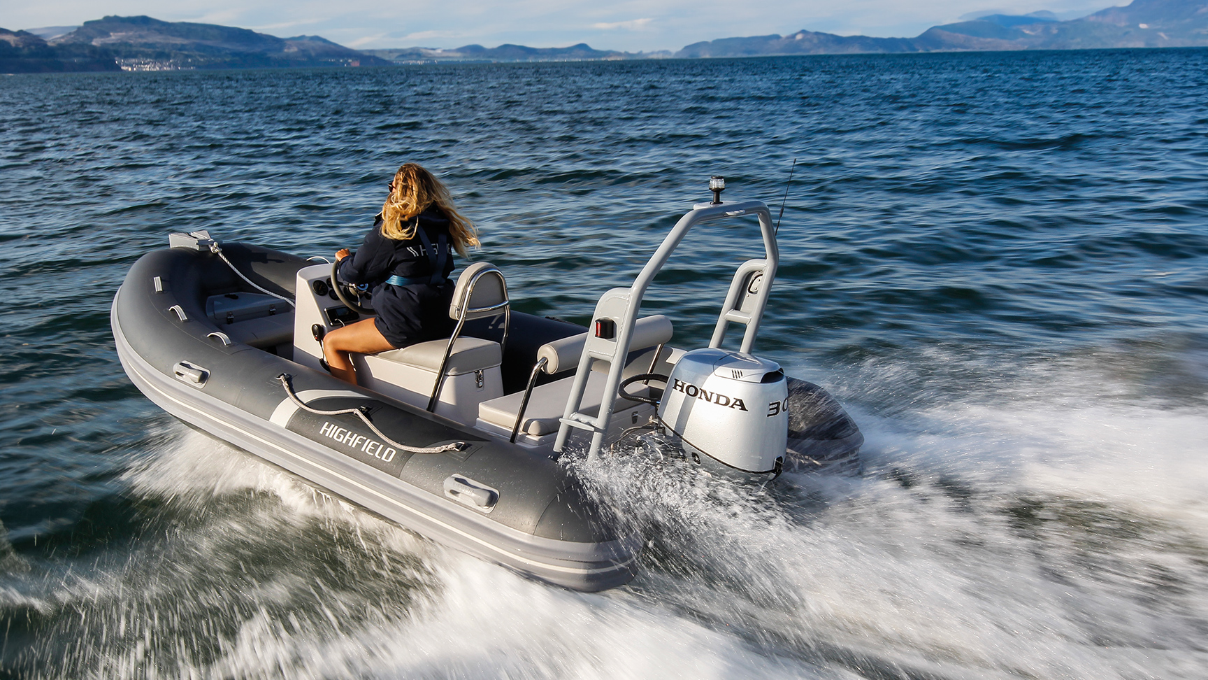 Donna su una barca Highfield con motore Honda BF30 in località oceanica.
