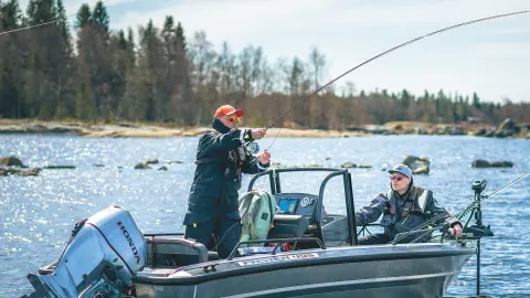 Uomini che pescano da una barca con motore Honda BF30 sul lago.