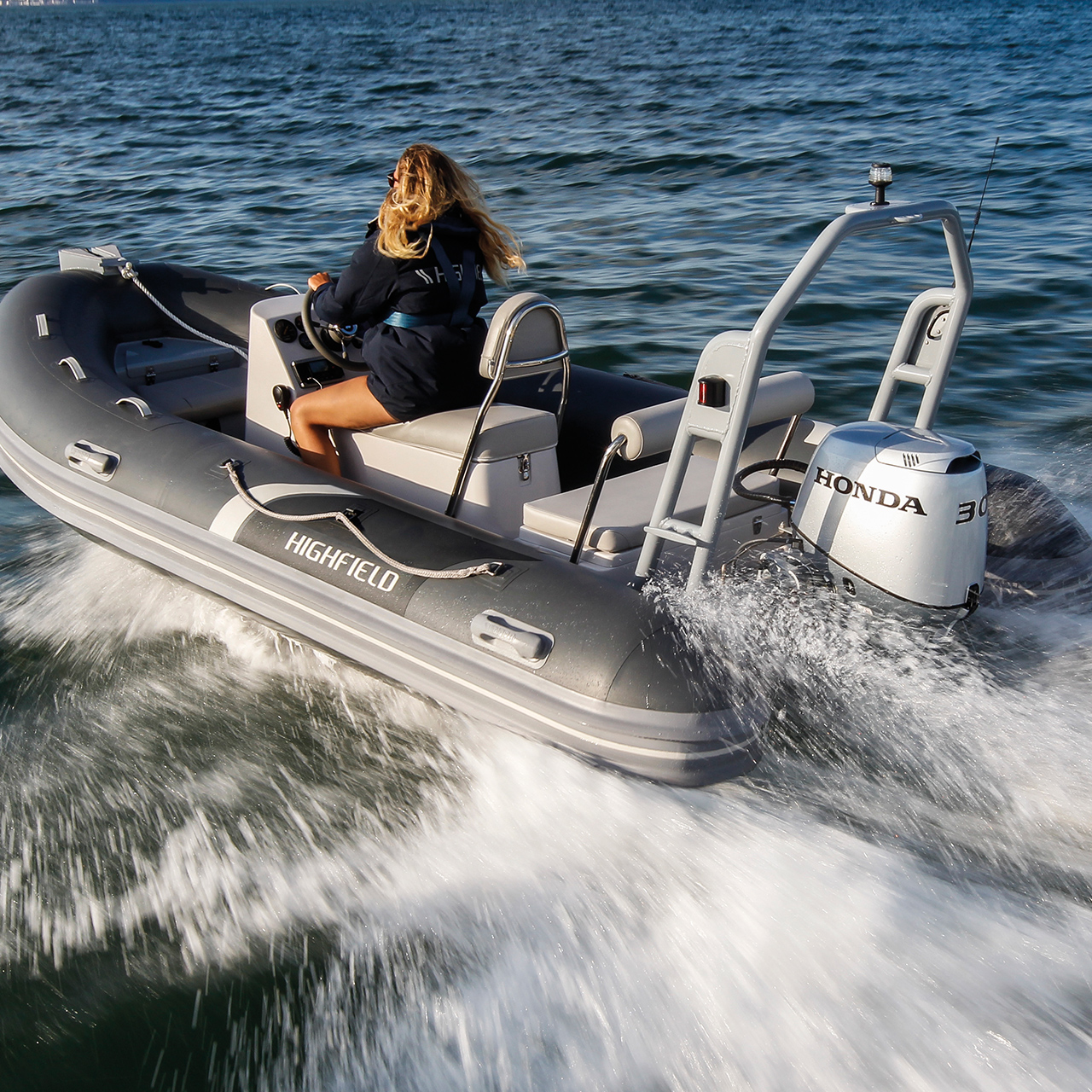 Donna su una barca Highfield con motore Honda BF30 in località oceanica.
