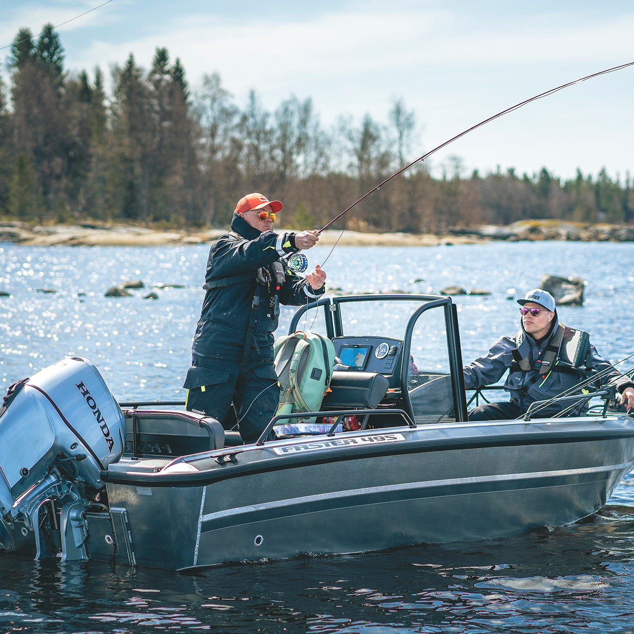 Uomini che pescano da una barca con motore Honda BF30 sul lago.