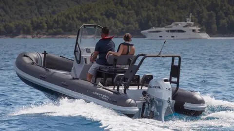 Vista posteriore di una coppia su una barca Highfield dotata di motore BF50 in località oceanica.