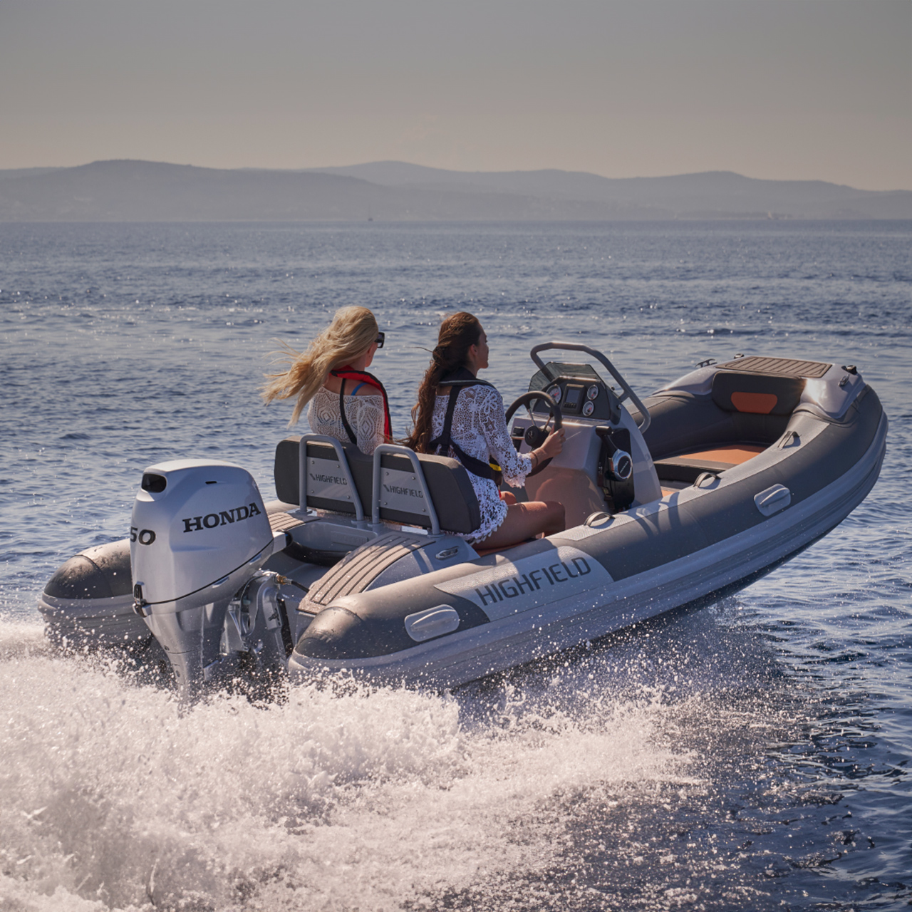 Due modelli su una barca Highfield con motore Honda BF50 in mare.