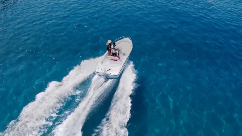 Coppia su una barca nell'oceano con un motore Honda BF.