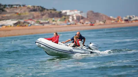 Famiglia su una barca in mare che utilizza il motore BF8-10.