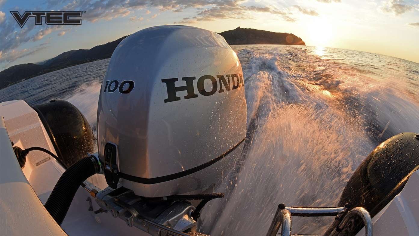 Inquadratura dal retro di un motoscafo in movimento con dettaglio del motore fuoribordo Honda BF100 al tramonto