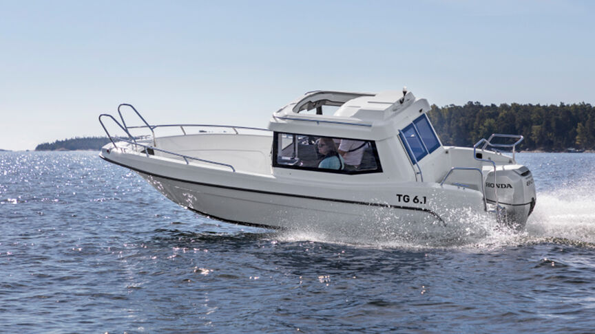 Modello nell'atto di sterzare una barca con motore BF80-100 in mare.