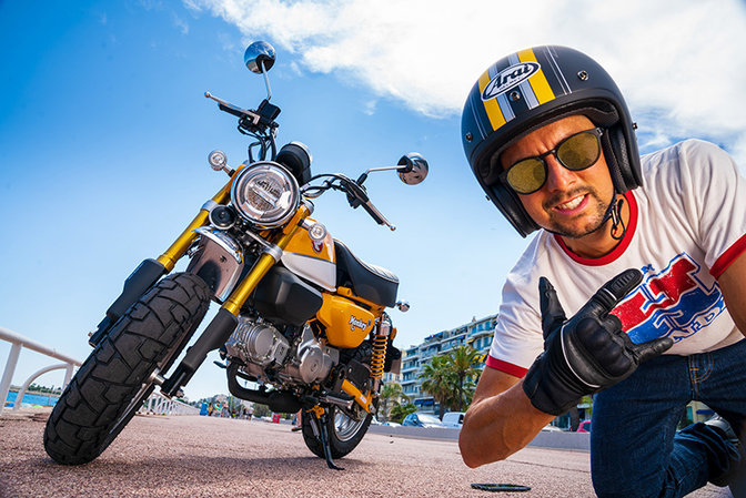 Monkey 125cc, inquadratura anteriore destra di tre quarti, uomo con casco sullo sfondo