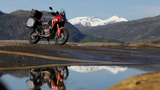 Africa Twin parcheggiata vicino a un fiume impetuoso in Norvegia