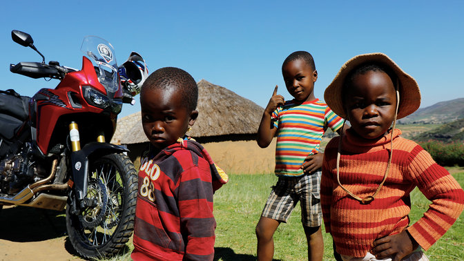 Bambini radunati all'esterno attorno a una CRF1000L Africa Twin
